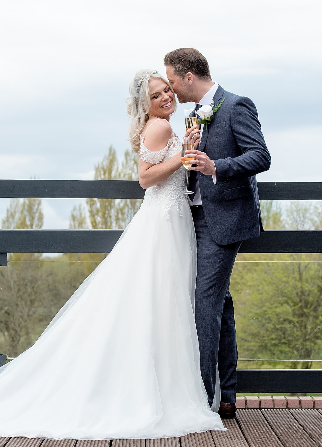 Couple embracing on the balcony with a glass of fizzy wine